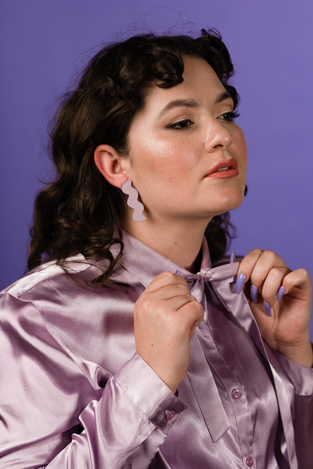 purple lavender zigzag leather stud earrings on dark curly haired model