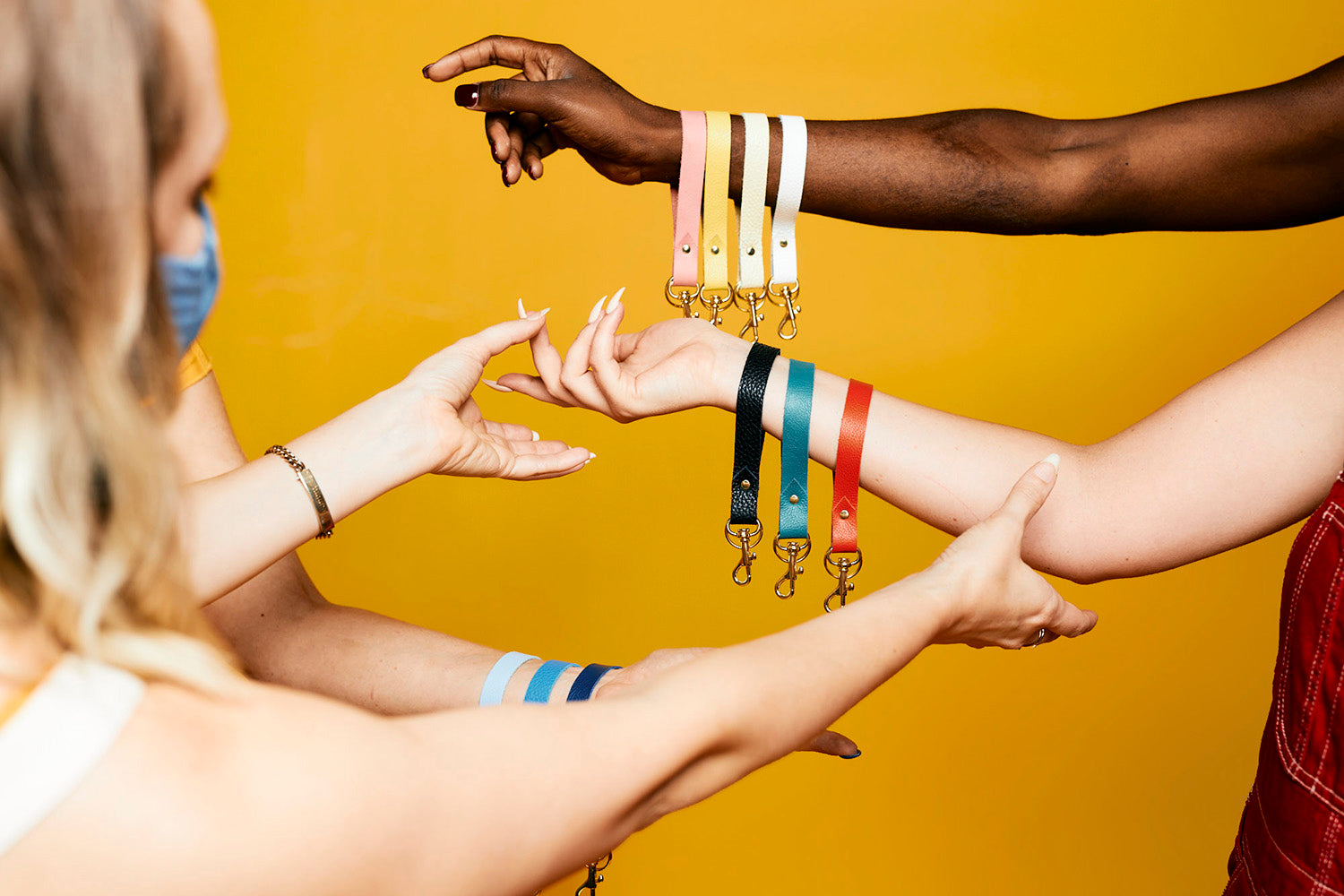 behind the scenes working with models showcasing different colored minimal leather keychains