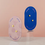 pink and blue cards displaying modern 14k gold plated pearl stud earrings with colorful gemstone inlay