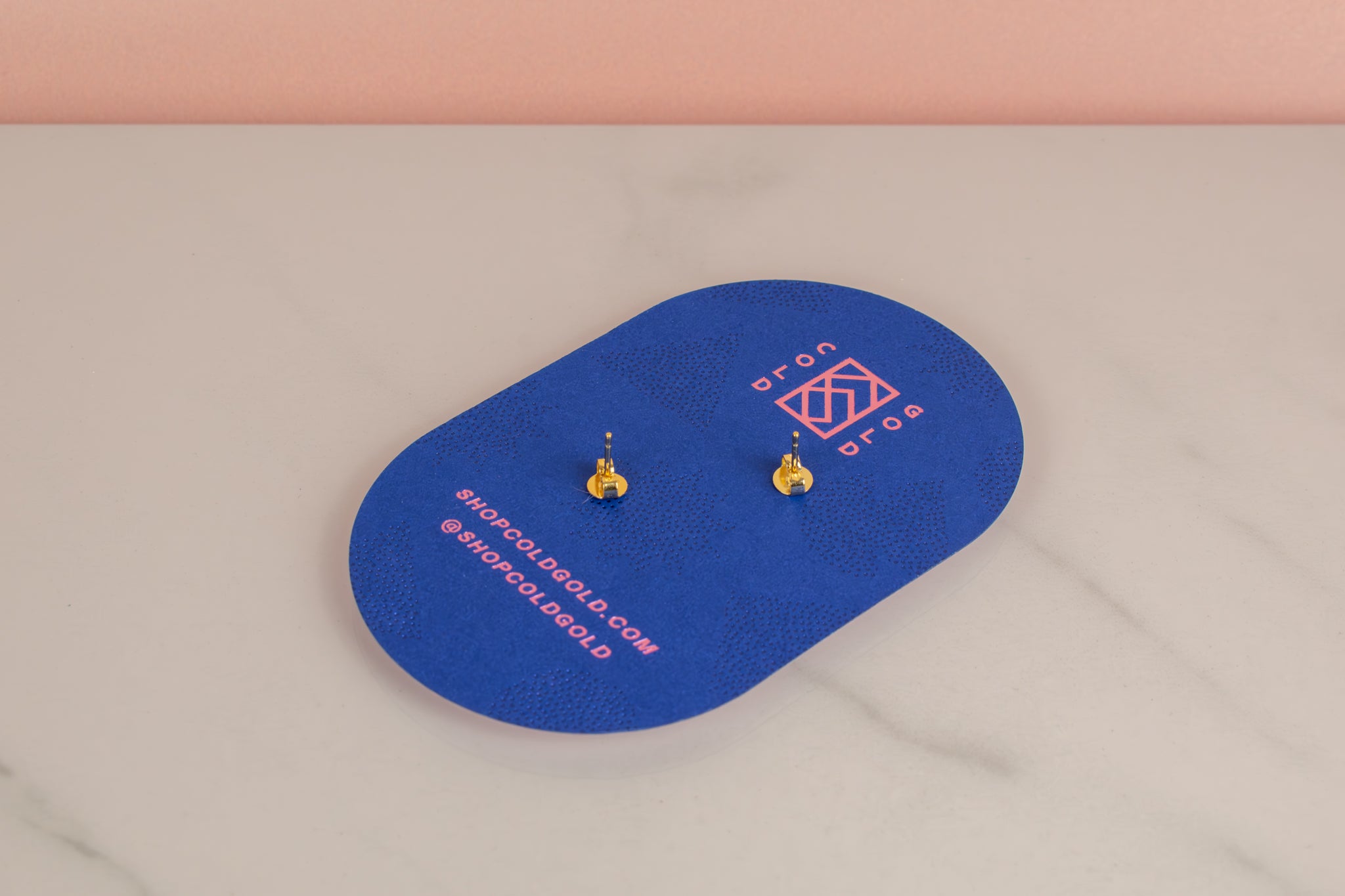 back of blue pill shaped cold gold earring card