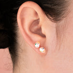 model wearing irregular pearl stud earrings with colorful cz gemstones