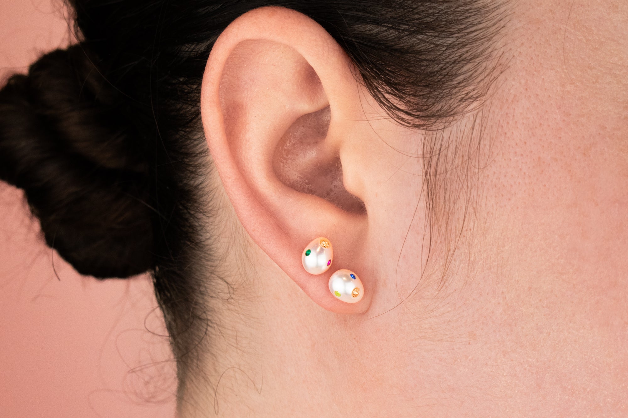 model wearing irregular pearl stud earrings with colorful cz gemstones