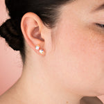 model wearing pair of baroque freshwater pearl earrings bejeweled with colorful gemstones