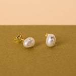 close up photo of baroque pearl stud earrings adorned with cz gemstones