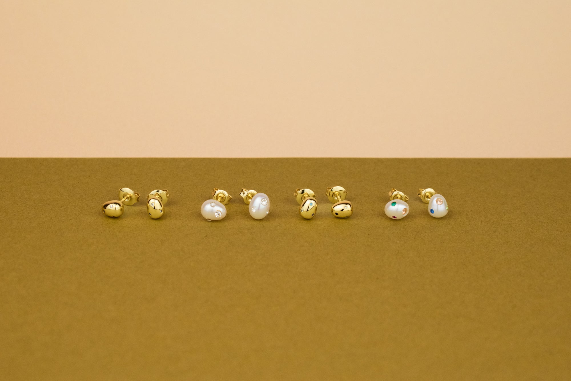 group photo of gold and pearl aura studs encrusted with crystal
 gemstones in varied sizes