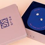 pair of freshwater pearl stud earrings with encrusted cz gemstones in cold gold branded jewelry travel tin