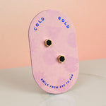 pink backer card displaying matte black hexagon gold plated earrings