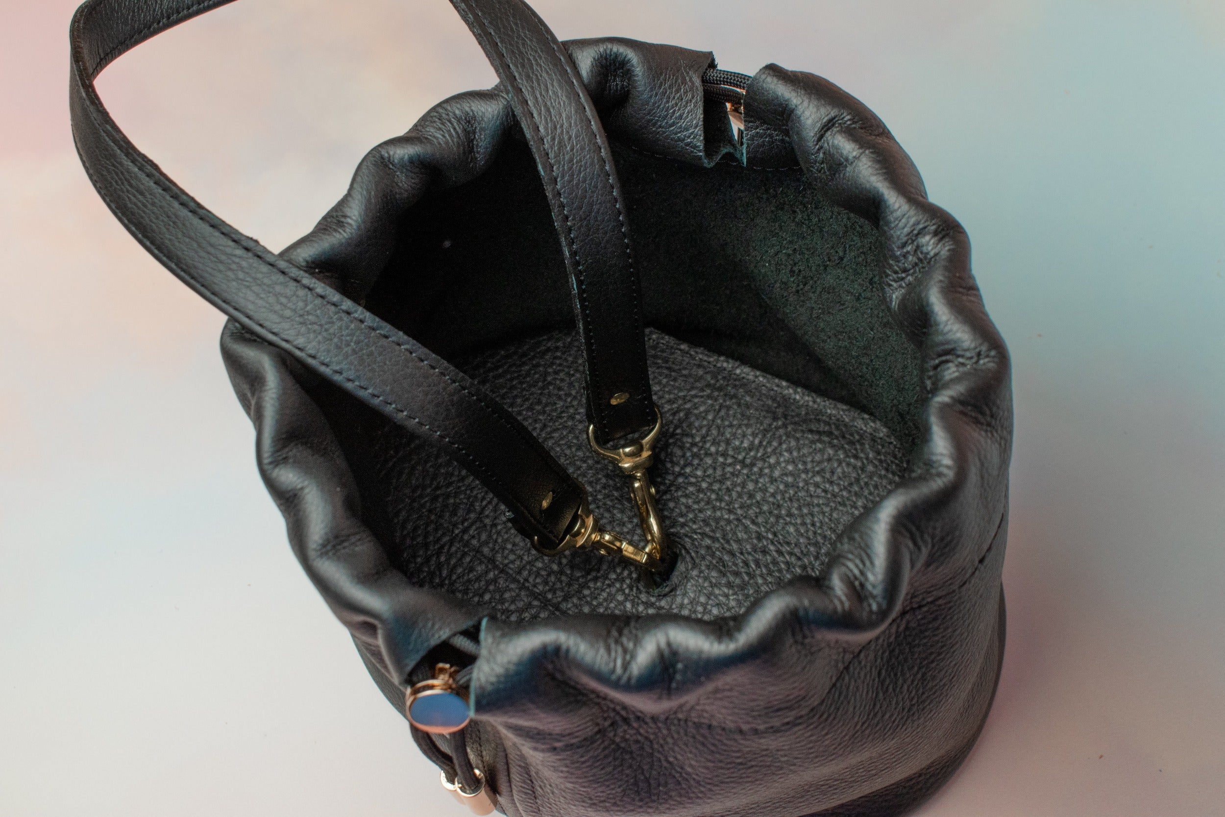 interior of pebbled black leather wristlet bag with adjustable hardware