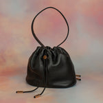 black leather slouchy handbag with unstructured silhouette and ruched drawstring