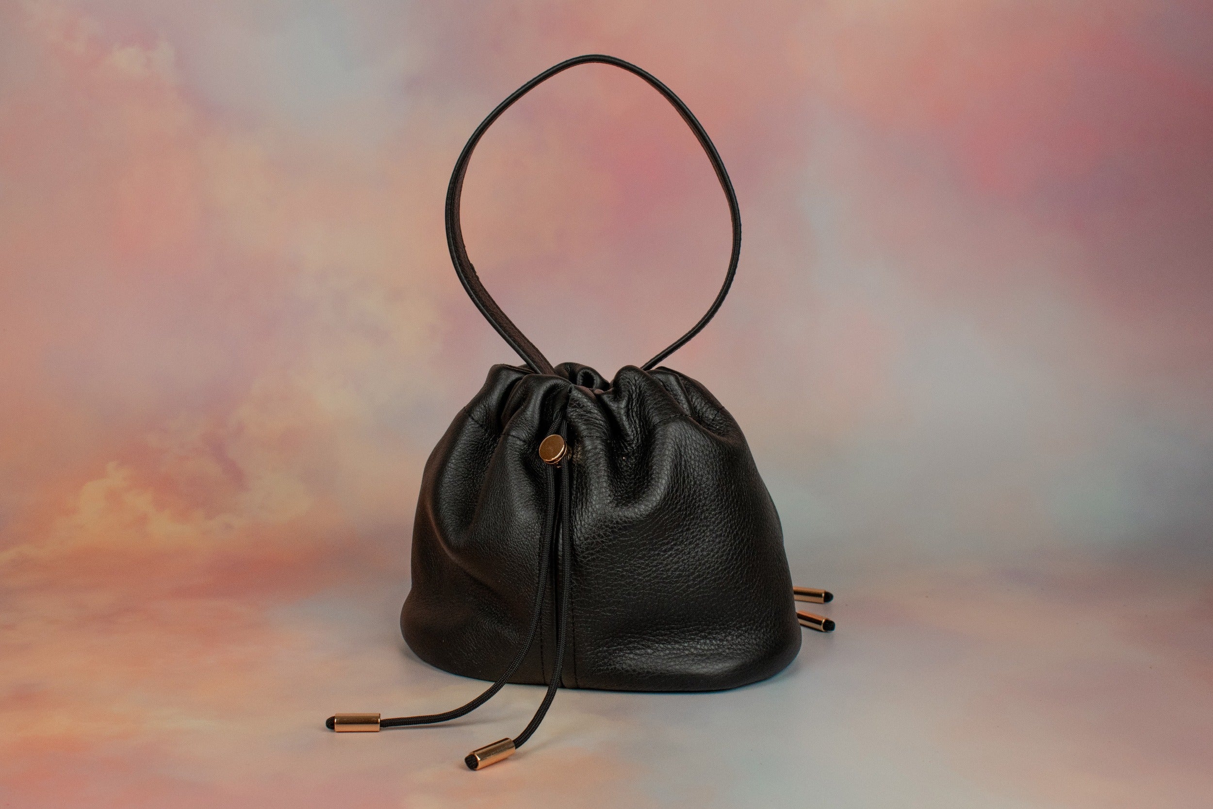 black leather slouchy handbag with unstructured silhouette and ruched drawstring