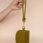 olive green wristlet dangling from finger including matching handmade keychain and leather wallet card case