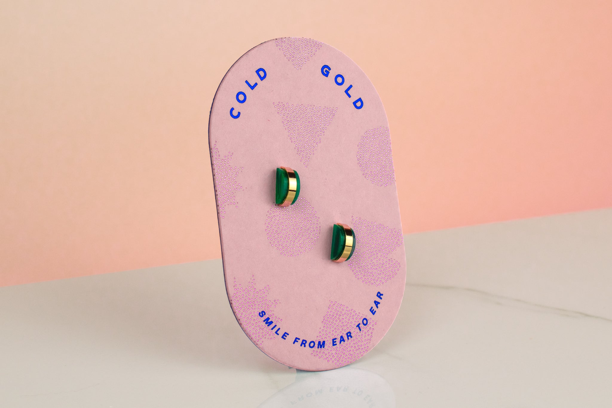 pink card displaying emerald gold hoop earrings may birthstone gift
