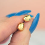 hand hold pair of gold baroque pearl earrings imbedded with micro crystal gemstones