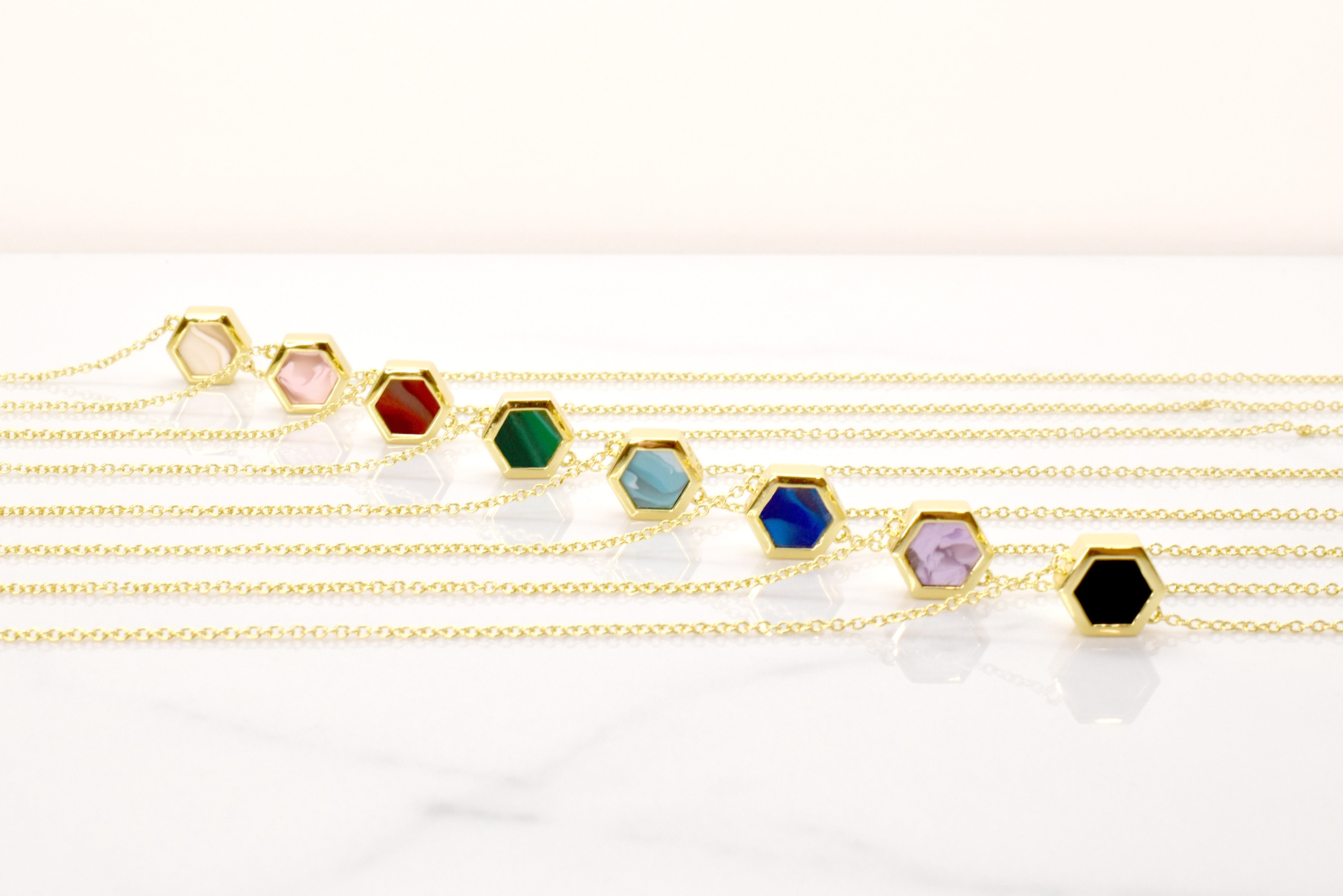 set of gold hexagon necklaces marbled clay jewelry 14k gold chain delicate short necklaces in crystal quartz, rose quartz, emerald, aquamarine, sapphire, and amethyst