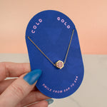 hand holding blue card displaying light pink polymer clay hexagon delicate necklace