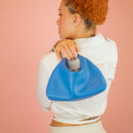 model holding small half moon convertible handbag over their shoulder