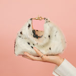 mini crescent slouchy handbag with convertible design in leather cowprint sitting on models outstretched hand