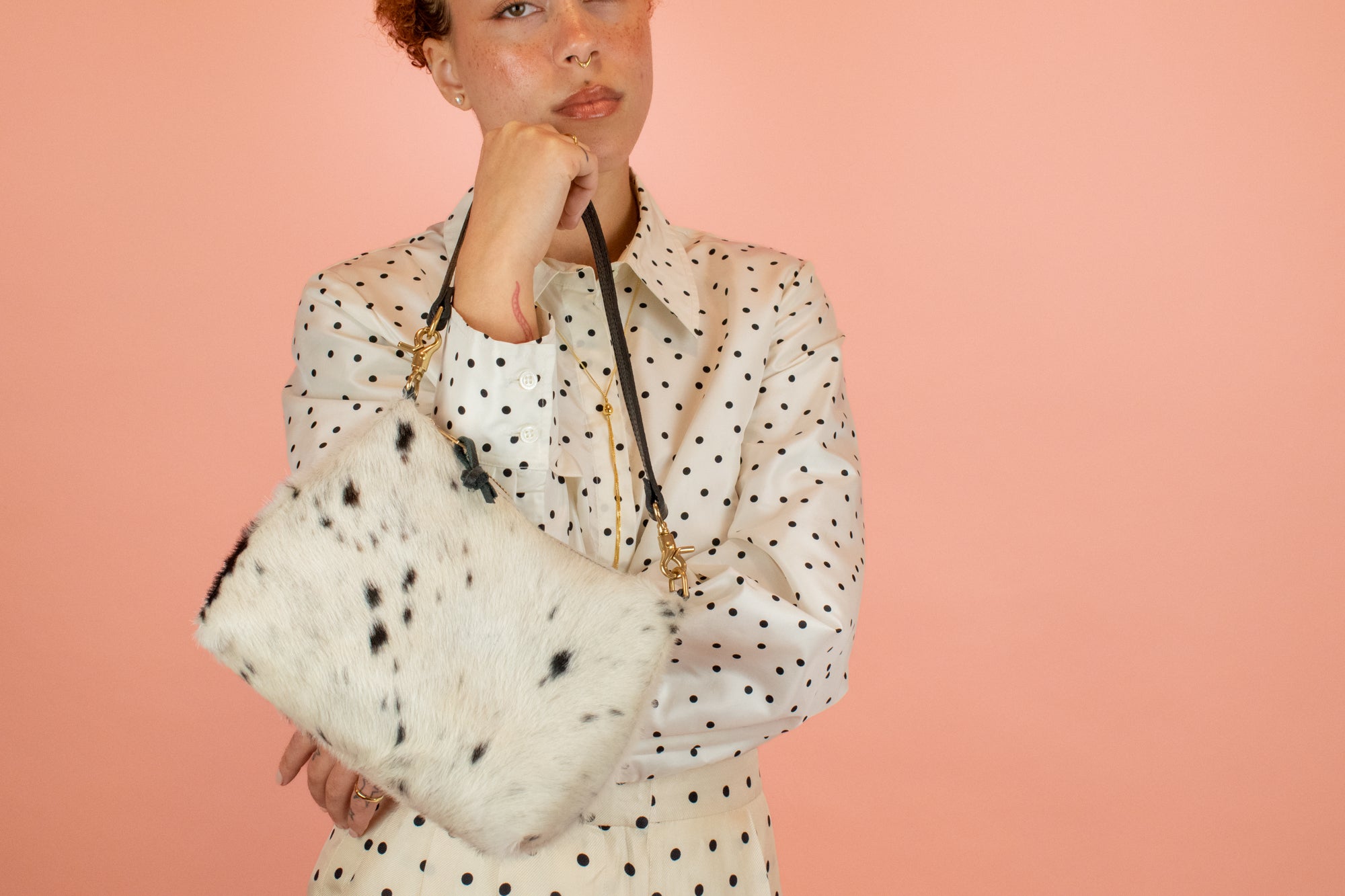 model holding up leather hair-on-hide handbag in cowprint