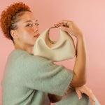 model posing with genuine pebble grain leather mini crescent bag with relaxed silhouette in bone white
