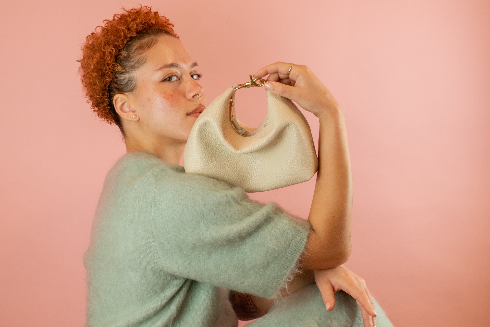 model posing with genuine pebble grain leather mini crescent bag with relaxed silhouette in bone white