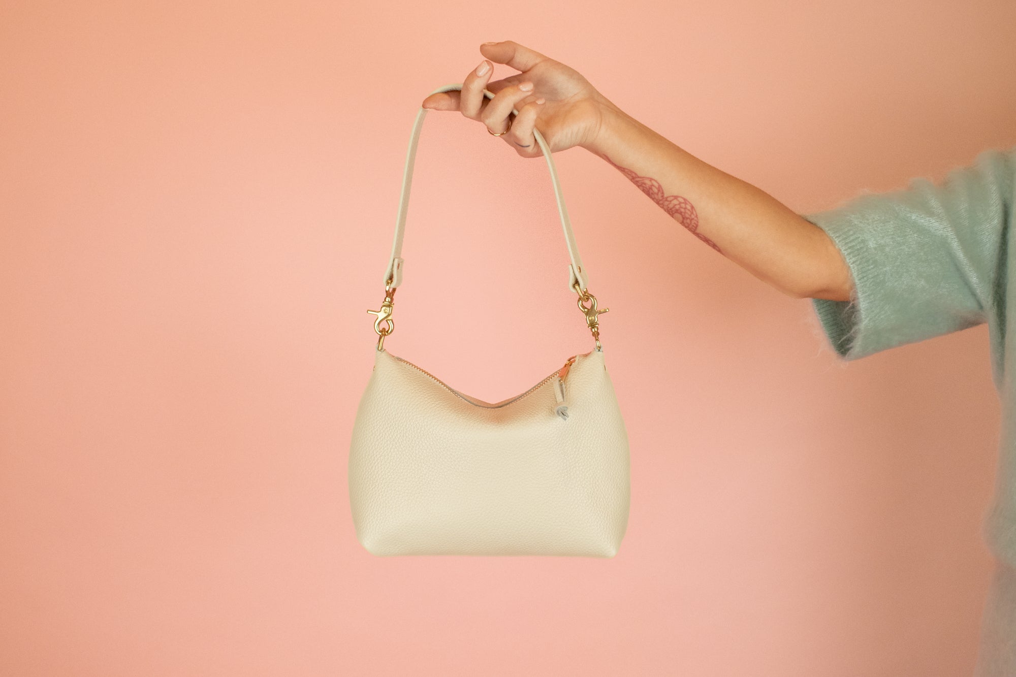modern slim leather shoulder bag with convertible design and gold hardware in ivory leather