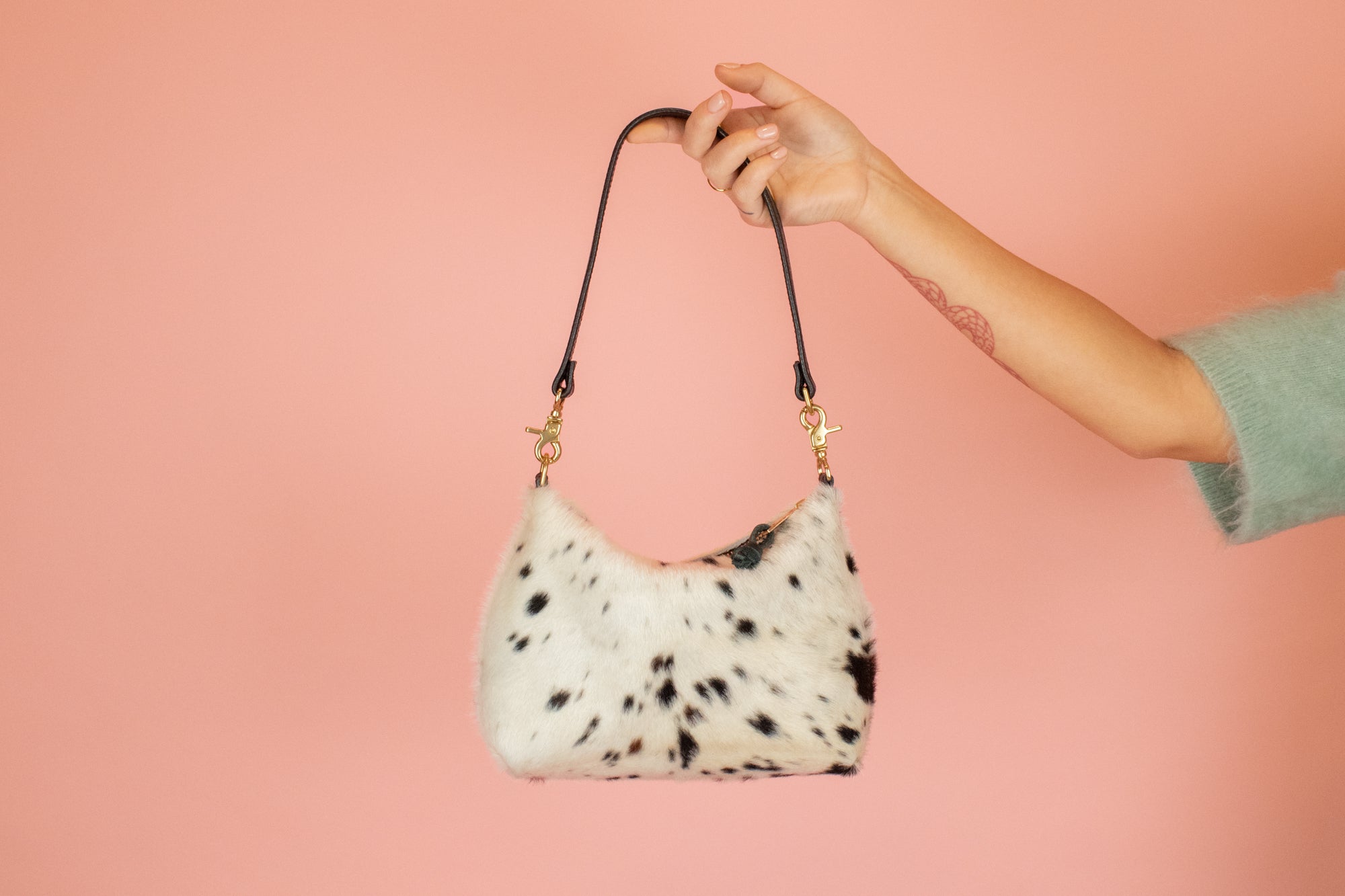 cowprint slim leather crescent shoulder bag with detachable black leather strap and gold hardware