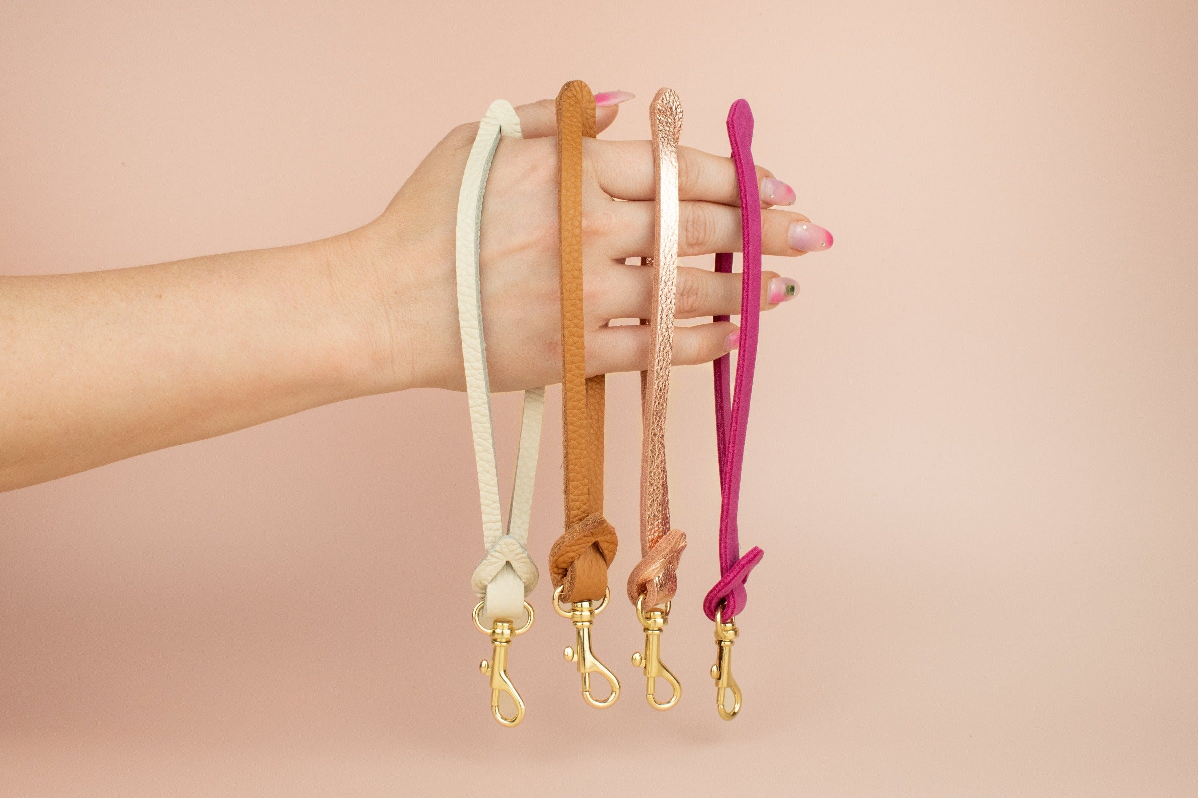 modern assorted colorful leather wrist straps keychains in ivory, brown, pink, and magenta