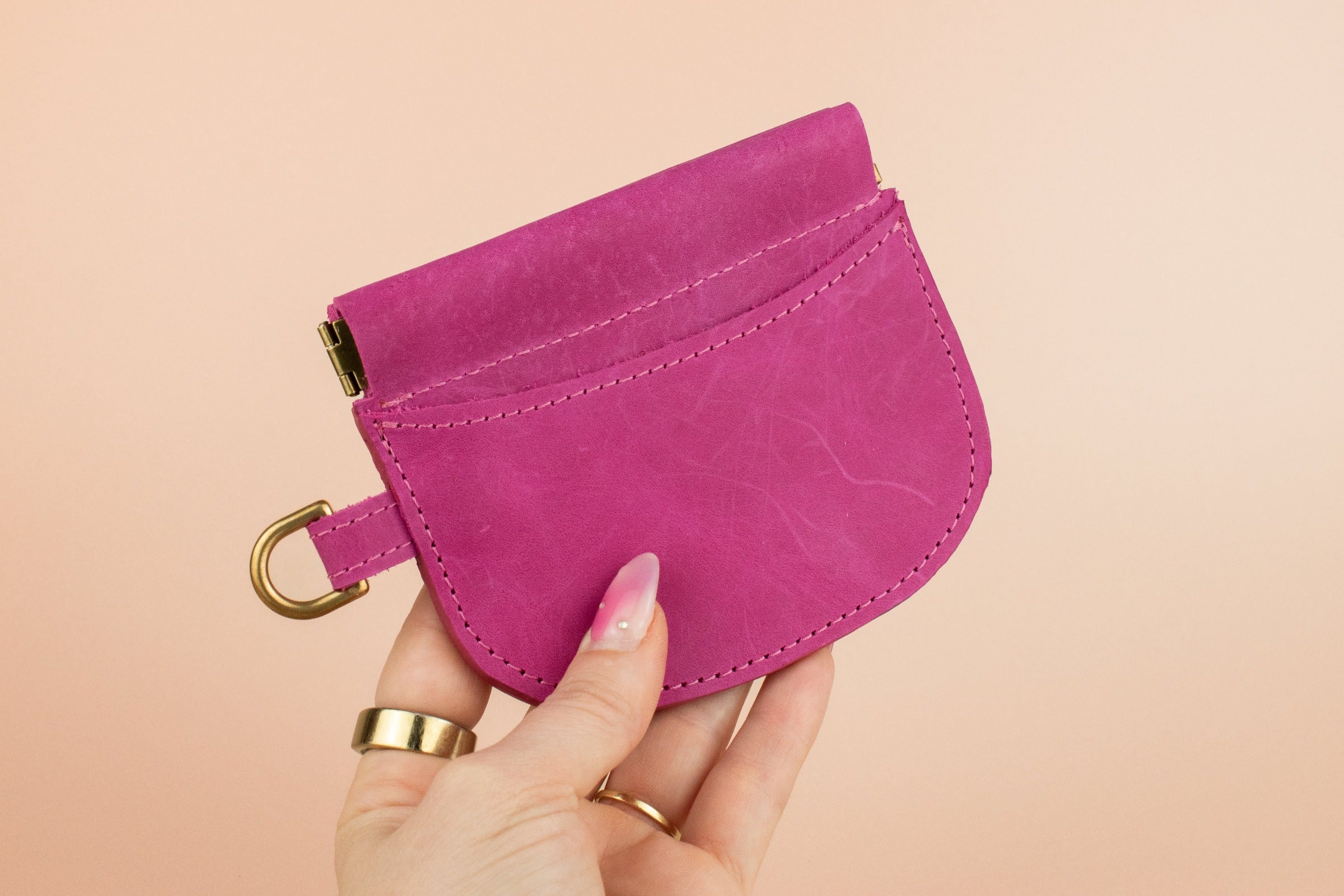 hand holding small simple handmade leather wallet card case wristlet with gold hardware