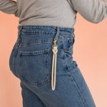 model wears handmade knotted leather keychain clipped onto blue jeans belt loop