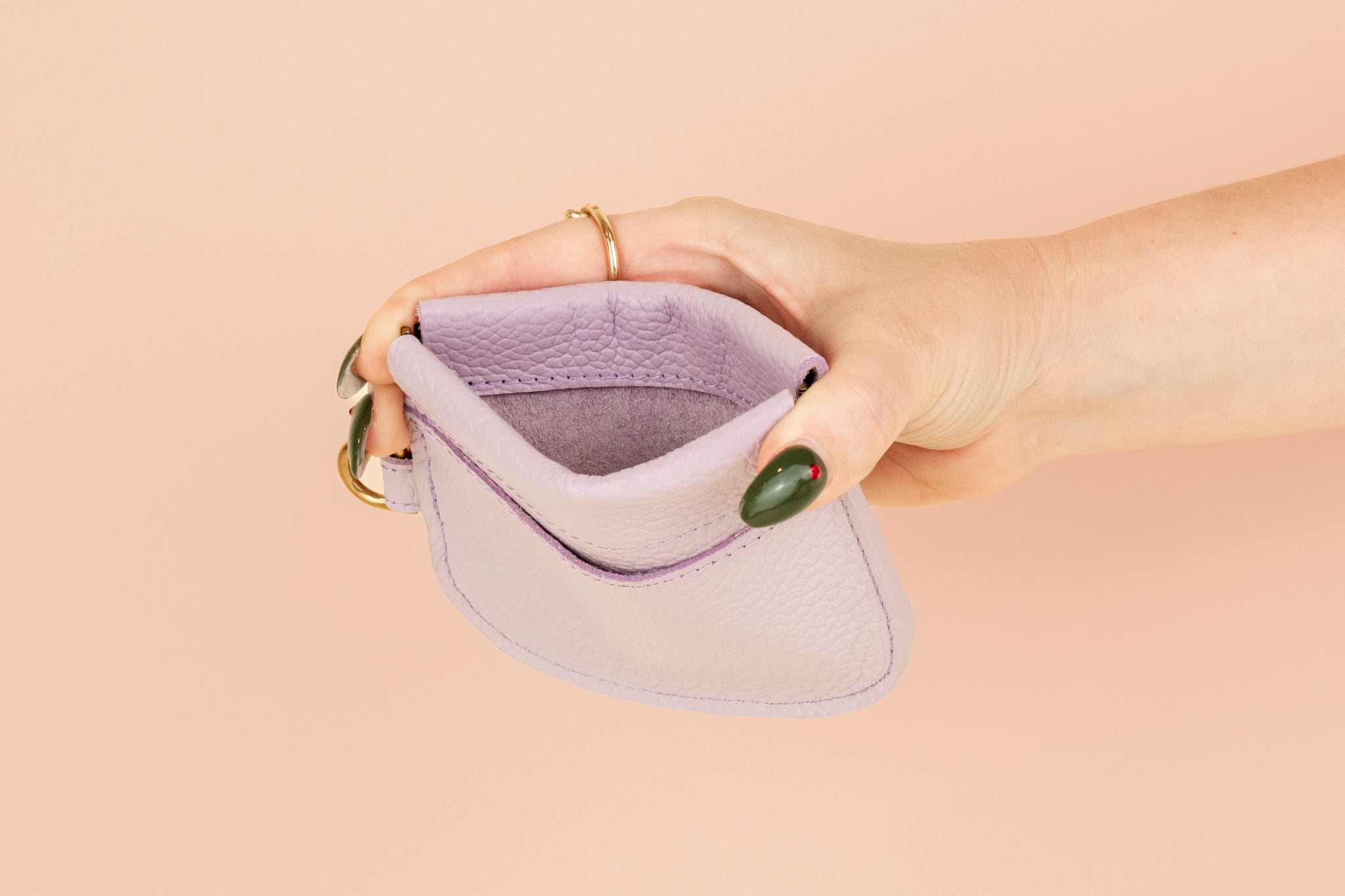 model holding open wallet to show interior pocket and strong stitching