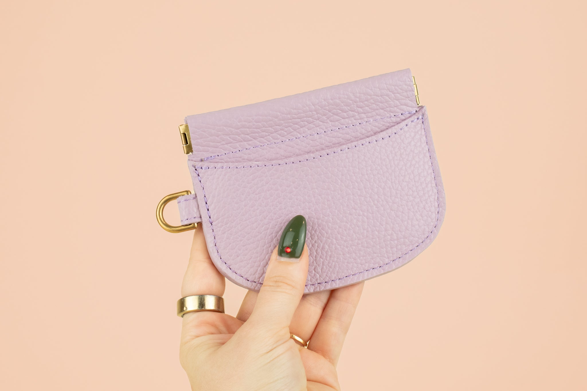 manicured hand holding up handmade cute card holder in lilac leather
