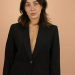 model in a black blazer wearing long gold modern adjustable bolo chain necklace