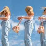 model flipping hair carrying rose gold medium sized shoulder bag with drawstring closure