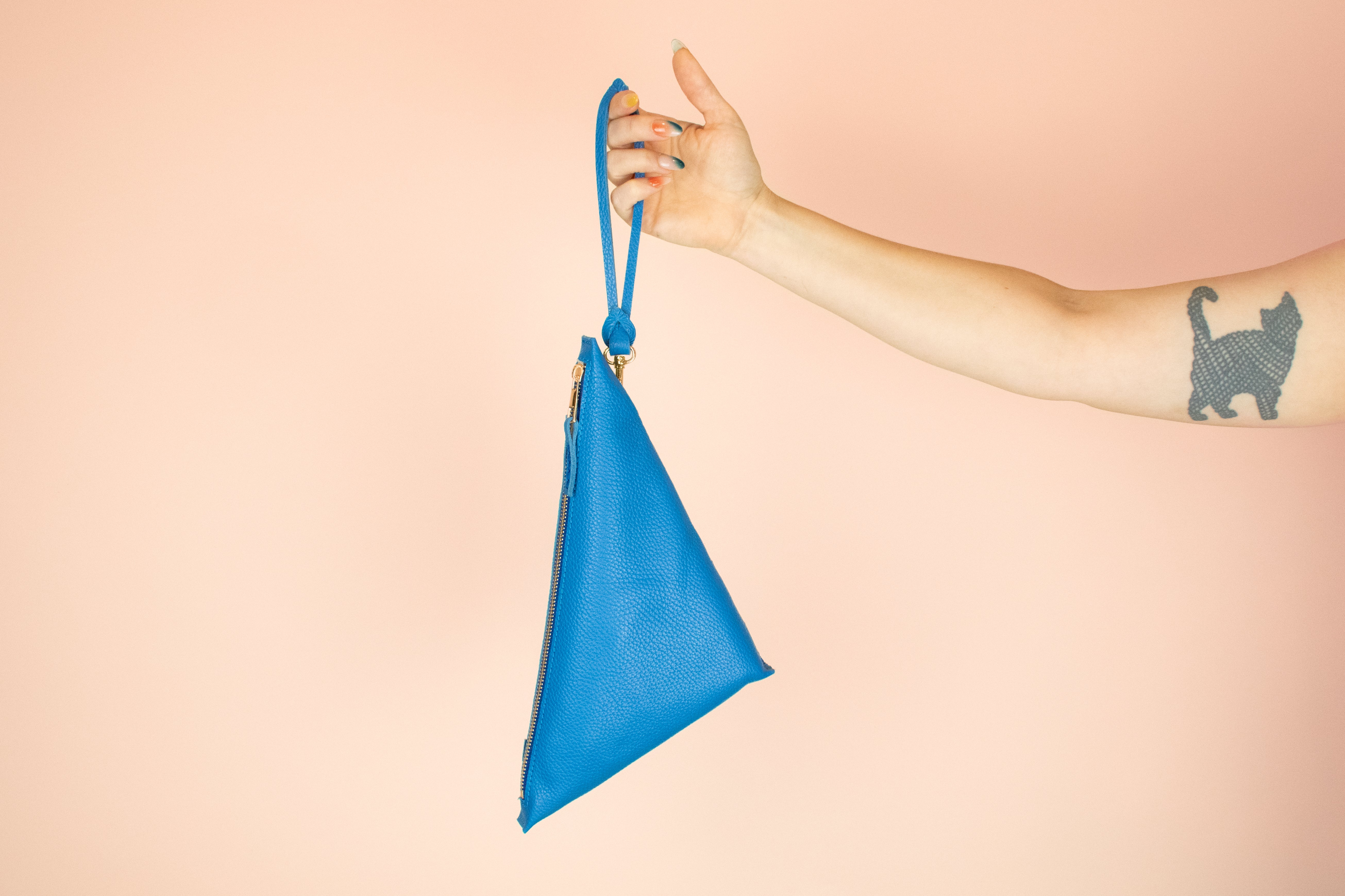 bright blue genuine leather clutch wristlet hanging from matching blue handmade leather keychain