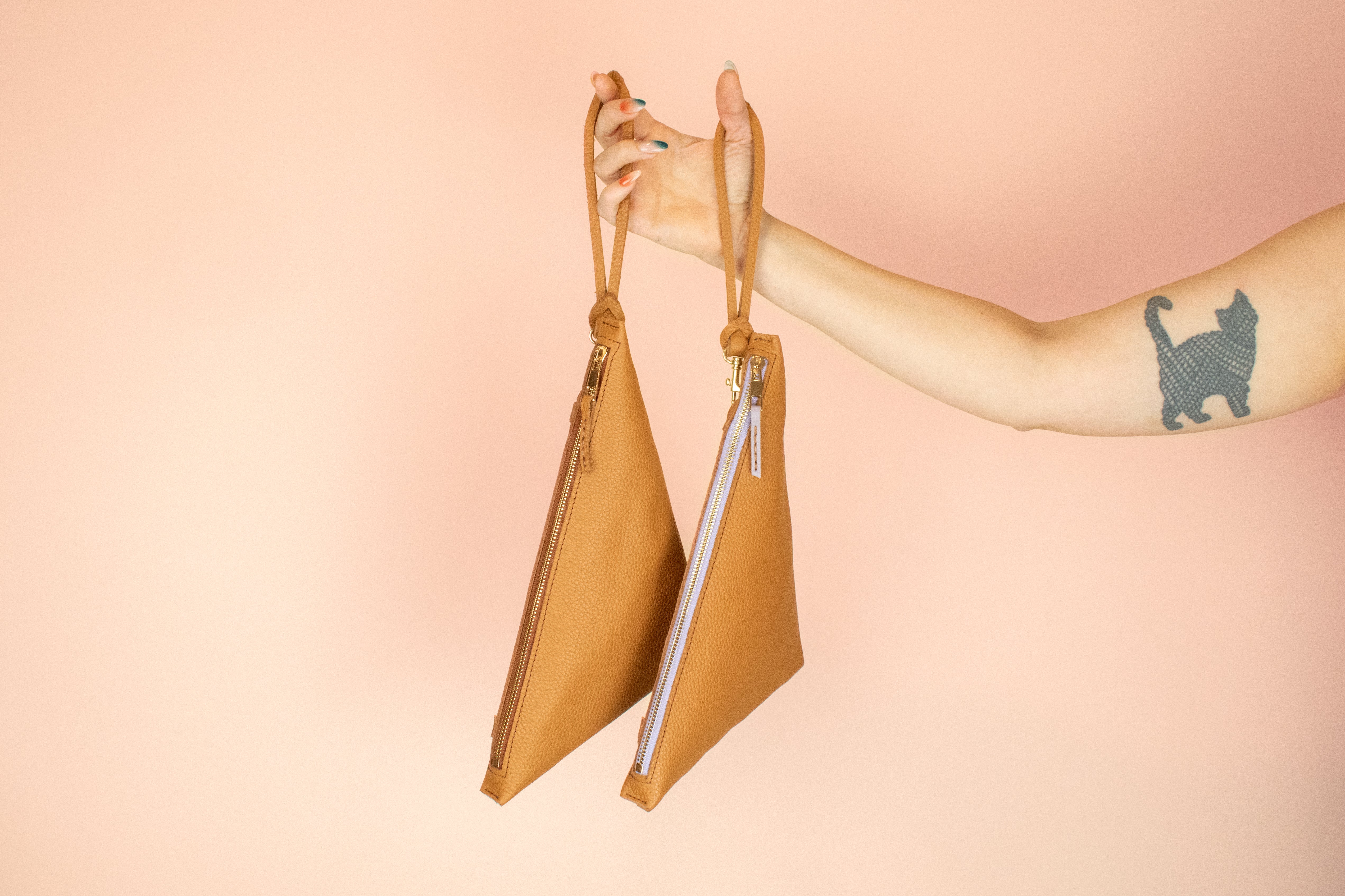 two caramel brown leather wristlets hanging from matching knot keychains