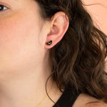 model wearing gold geometric stud earring in black terrazzo