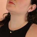 model wearing matching geometric gold earrings and necklace in unique dalmatian style