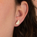 close up of models ear wearing modern moon earring in white terazzo