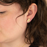 side profile of model wearing a modern gold half moon earring in mosaic style