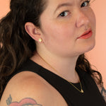 brunette model looking into camera wearing matching terrazzo desgign hexagon 14k gold necklace and earrings