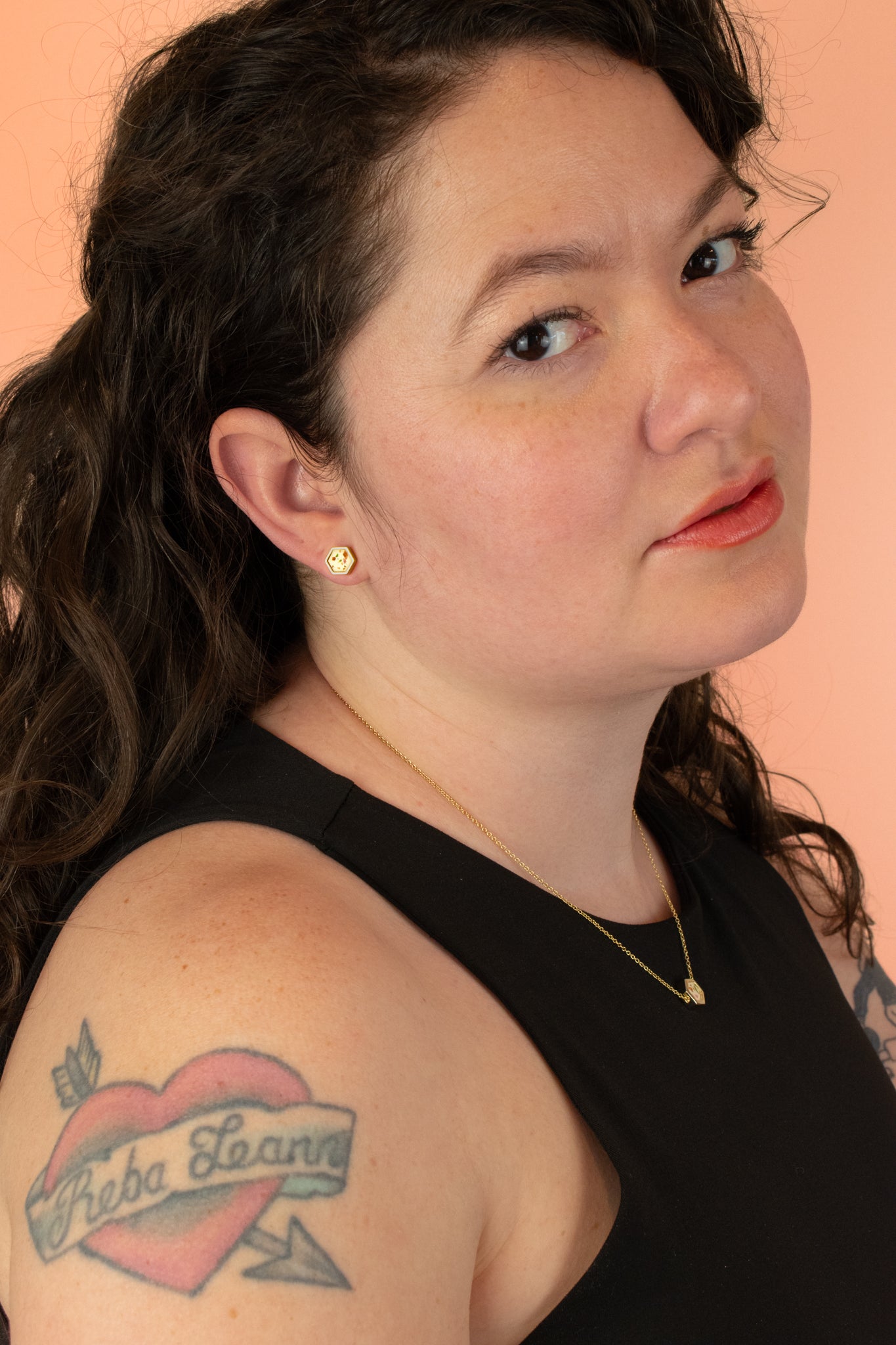 brunette model looking into camera wearing matching terrazzo desgign hexagon 14k gold necklace and earrings