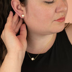 model wearing matching gold hexagon necklace and earrings in speckled terrazzo stone