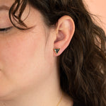 brunette model wearing 14k gold plated black and white statement triangle earrings