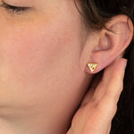 model wears stone inspired geometric stud earrings in terrazo and gold