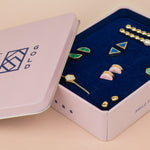 cold gold pink jewelry box with blue plush interior with 16 stud earring slots featuring various cold gold jewelry pieces designed in usa