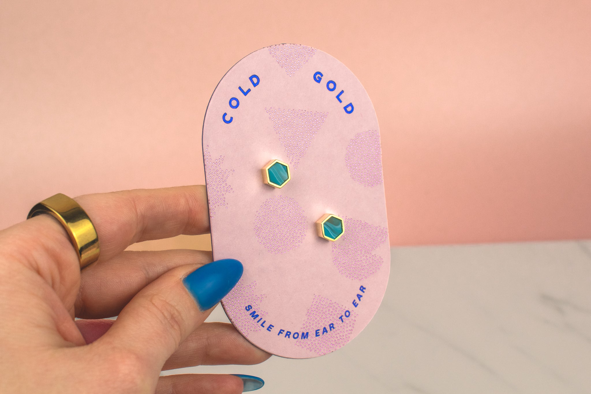 hand holding pink cold gold card with sterling silver and aquamarine marble polymer clay gold simple stud earrings birth stone march jewelry earrings