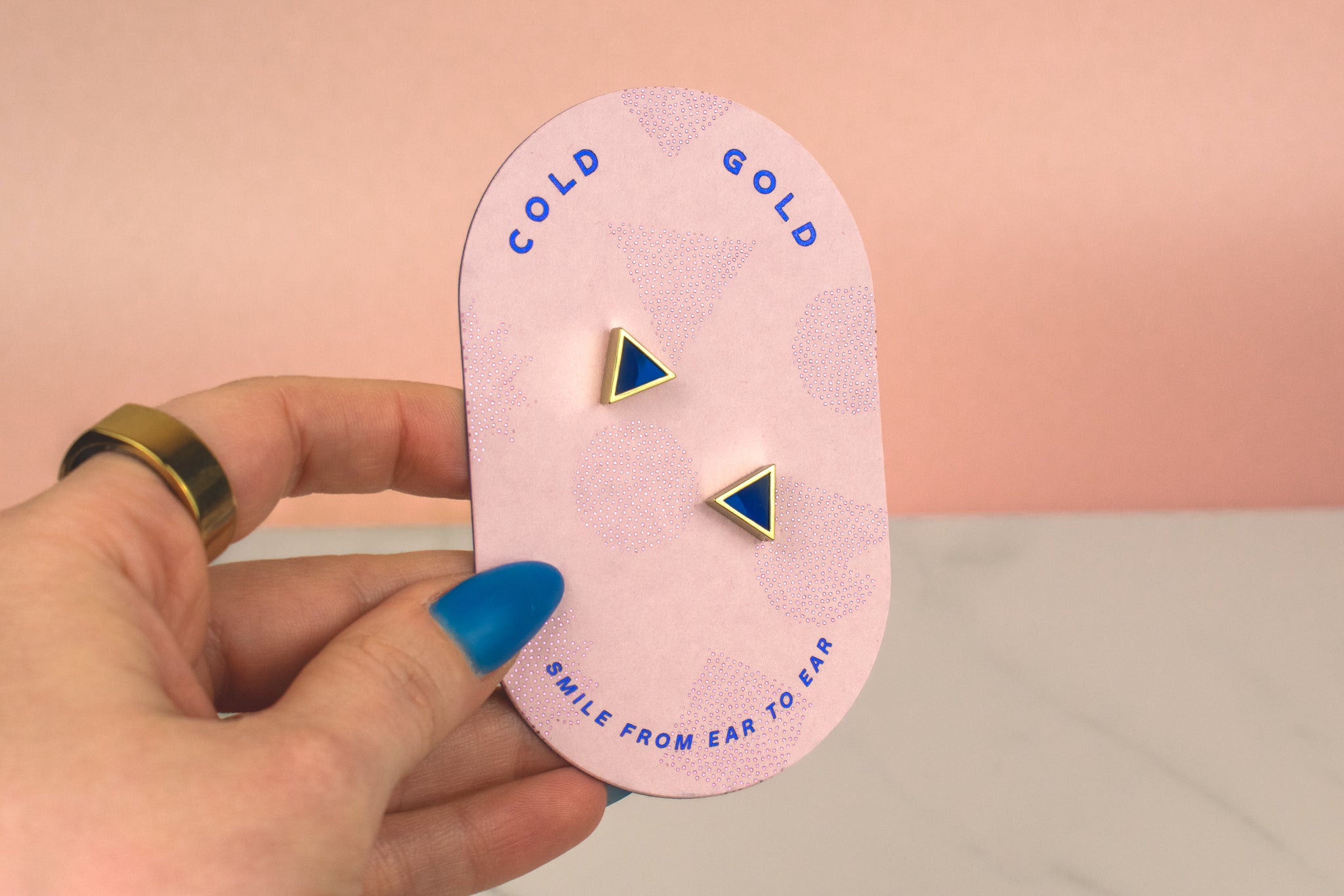 hand holding pink card displaying pair of blue sapphire gemstone inspired earrings sterling silver posts september birthstone gift