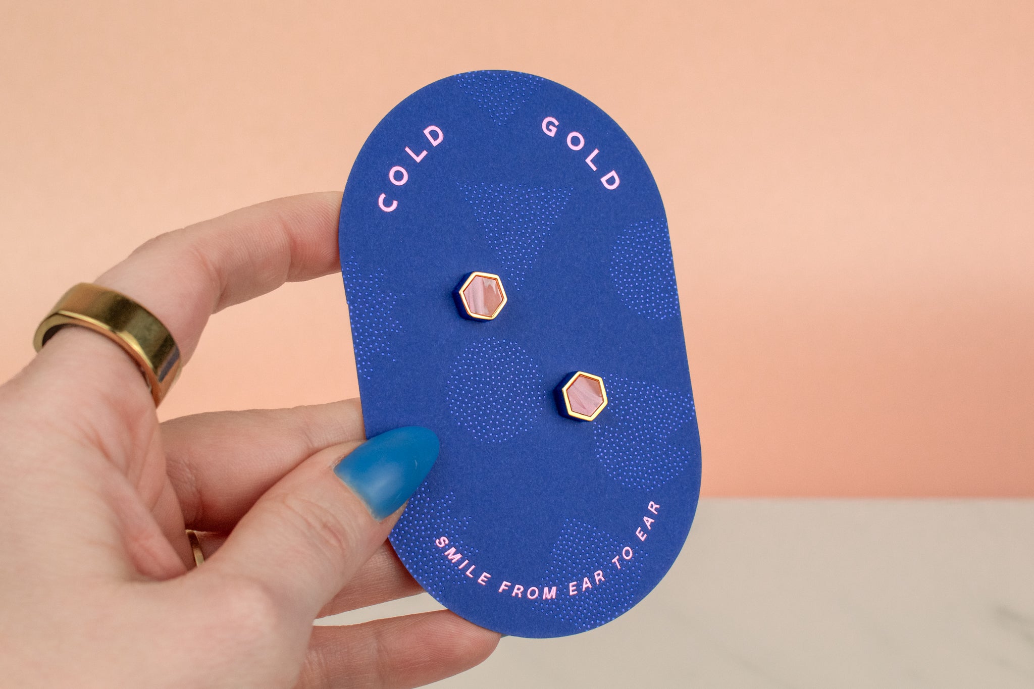 hand holding pair of rose quartz marbled clay handmade minimal earrings