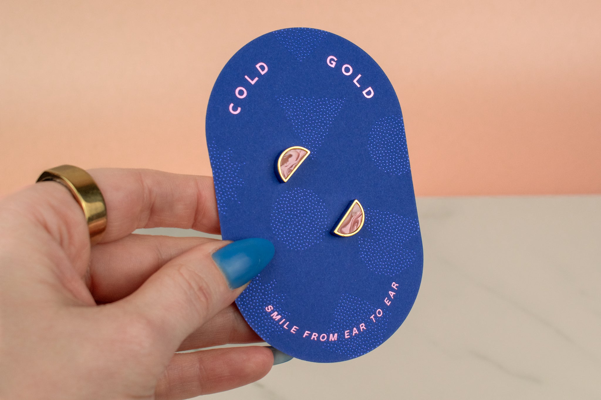 blue pill shaped card with celestial stud earrings in petal pink marble