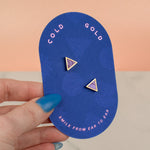 hands holding blue card with a pair of earrings in lavender marble and 14k gold on it pill shaped
